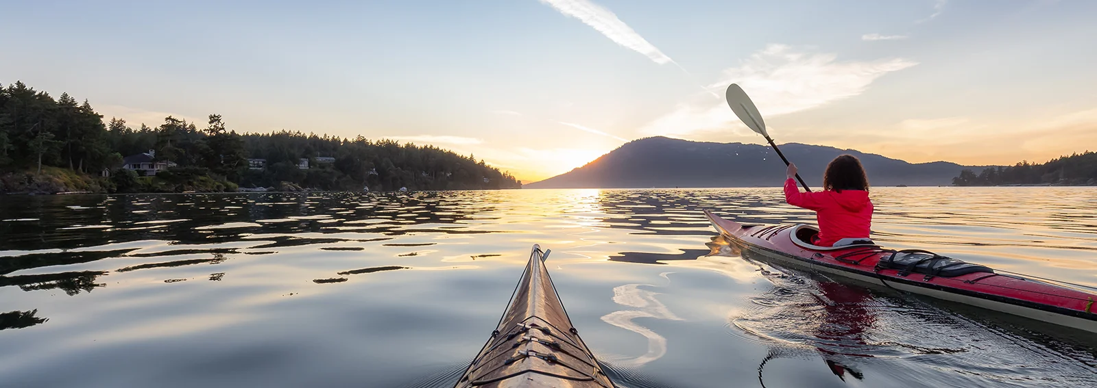 Woman kayaking in a  sunny summer sunset