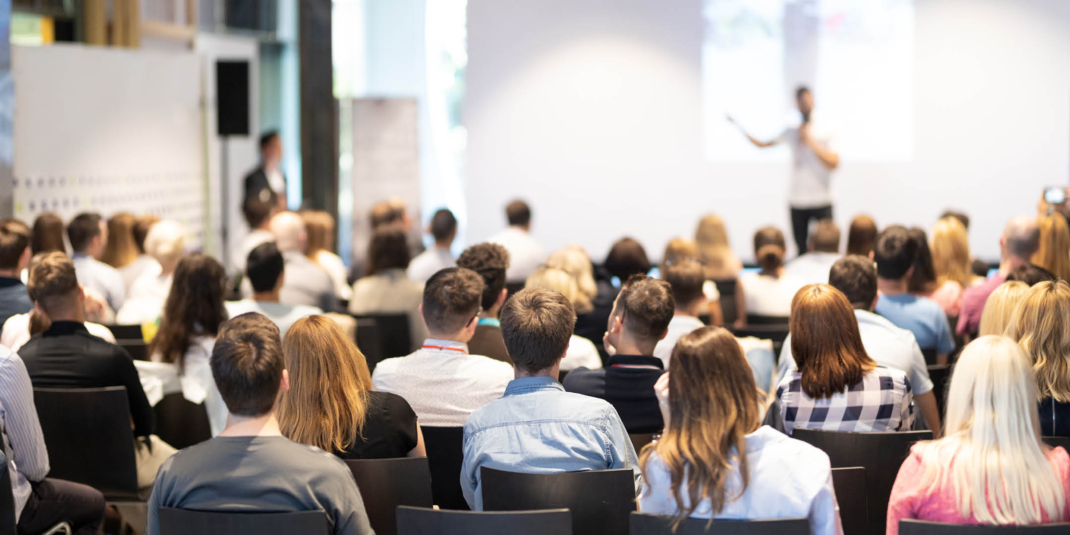 Group of people listening to speaker at conference