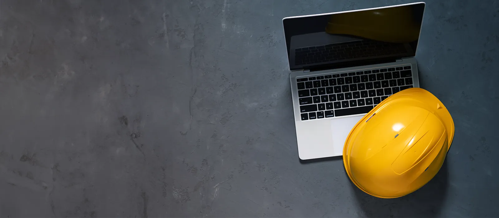 Aerial view of a construction hat beside a laptop.