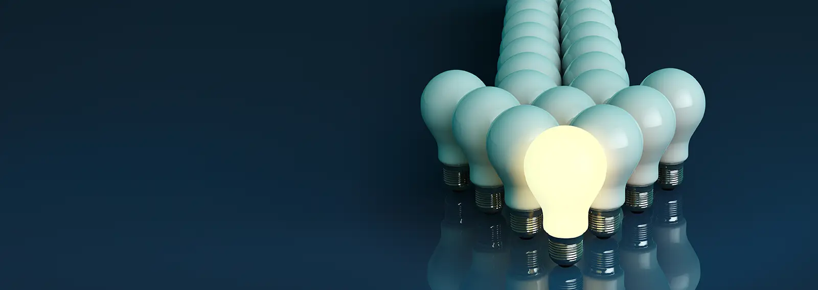 Leadership concept One glowing light bulb standing in front of bulbs arrow on a black background