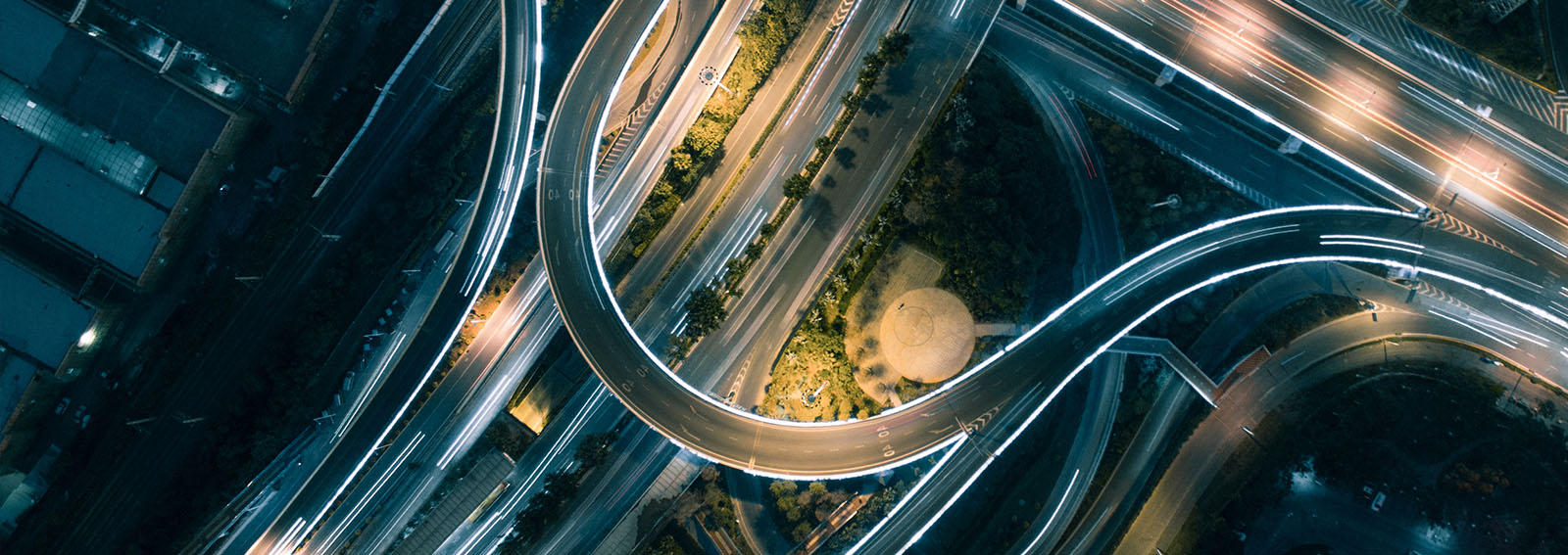 winding roads and overpasses with light trails