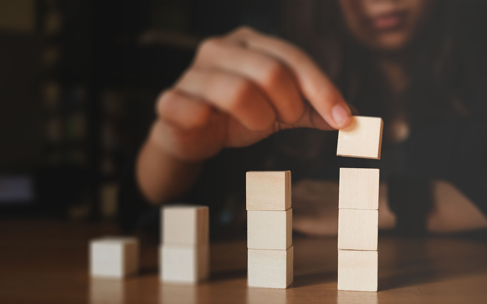 Closeup of a hand moving wooden blocks