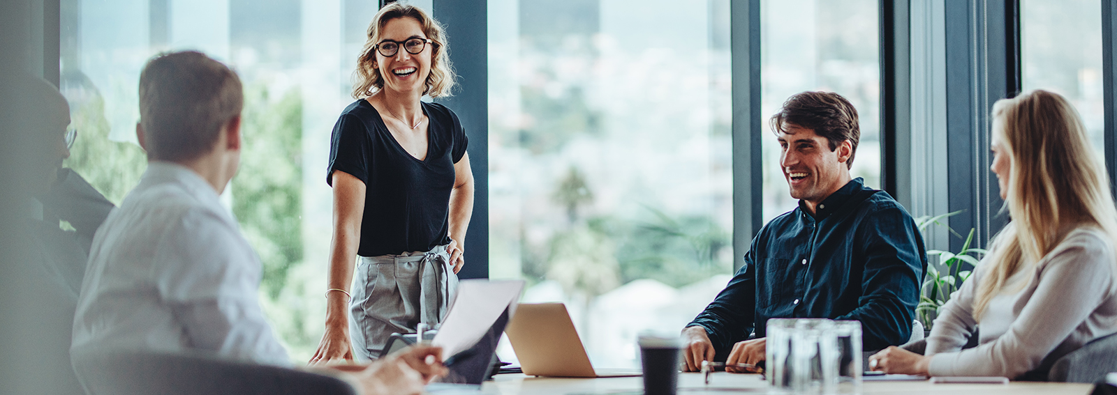 Équipe de travail collaborant sur une table avec des ordinateurs portables ouverts