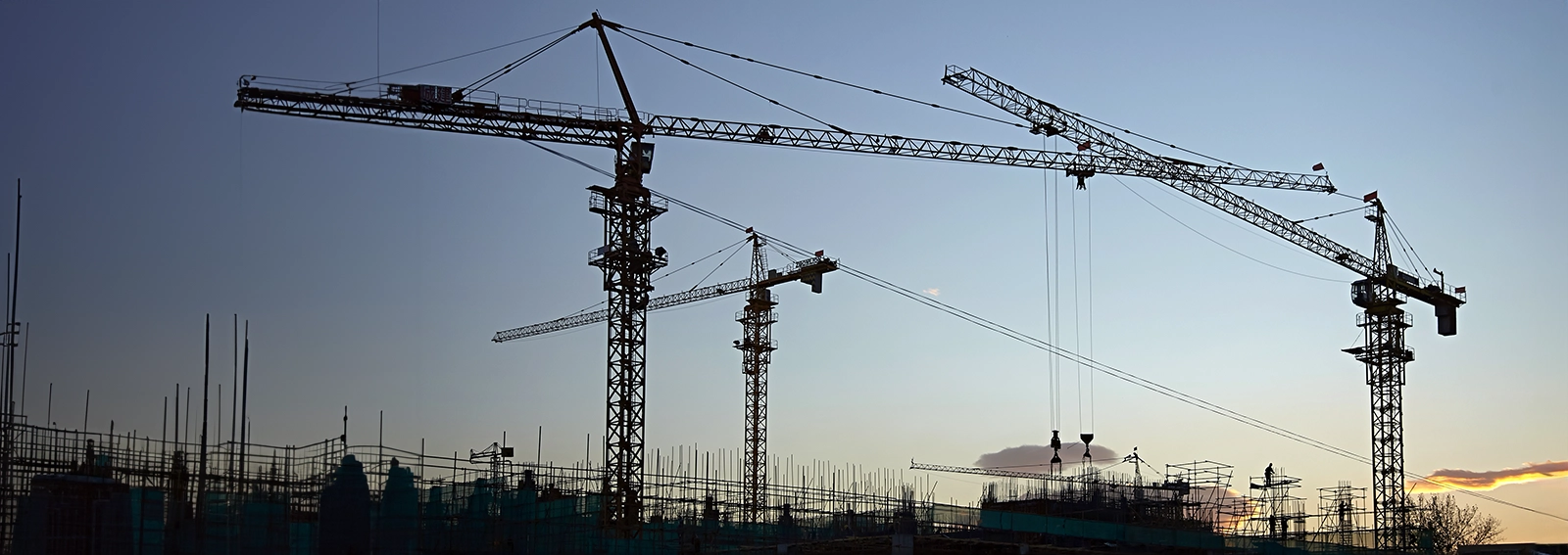 Construction towers and scaffolding captured at sunset.