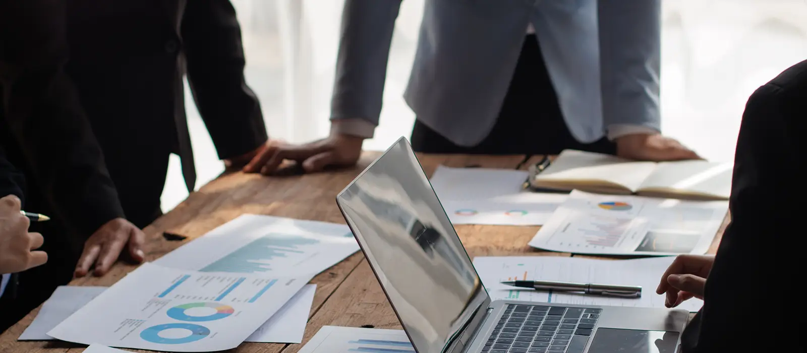 Teamwork of businessman analyzing cost graphs on table at conference room