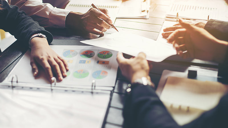 Business people analyzing data at table