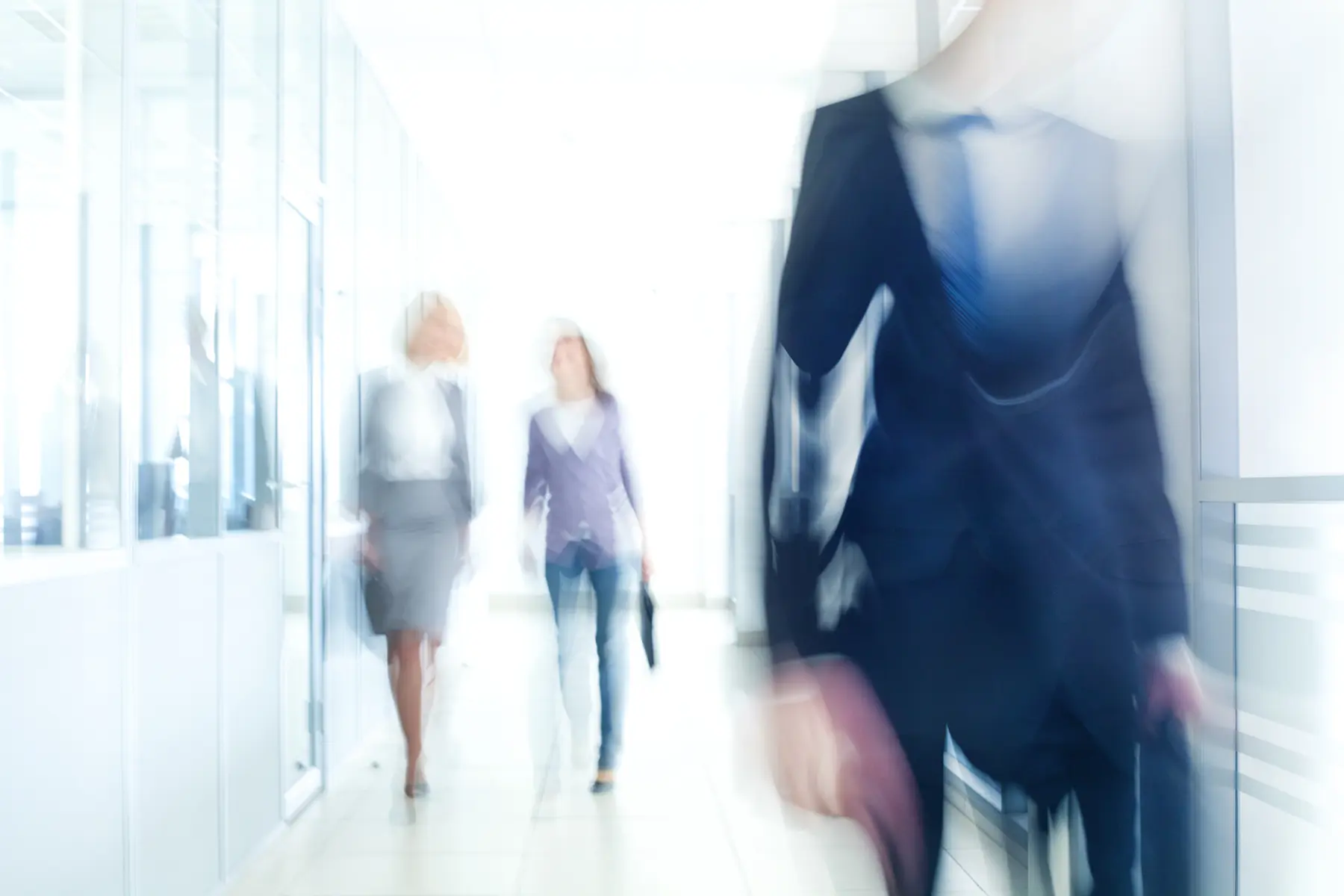 blurred image of people walking down a hall