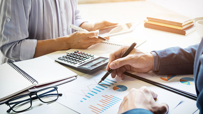 Businessmen working on documents together at table