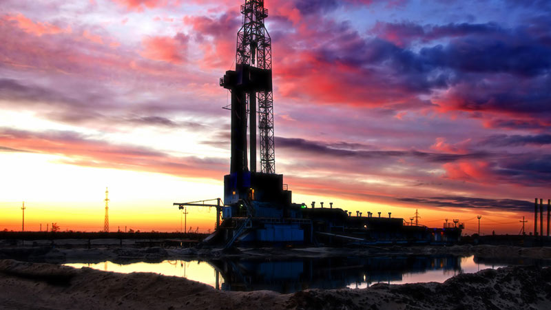 oil rig in a field with the sun setting in the background