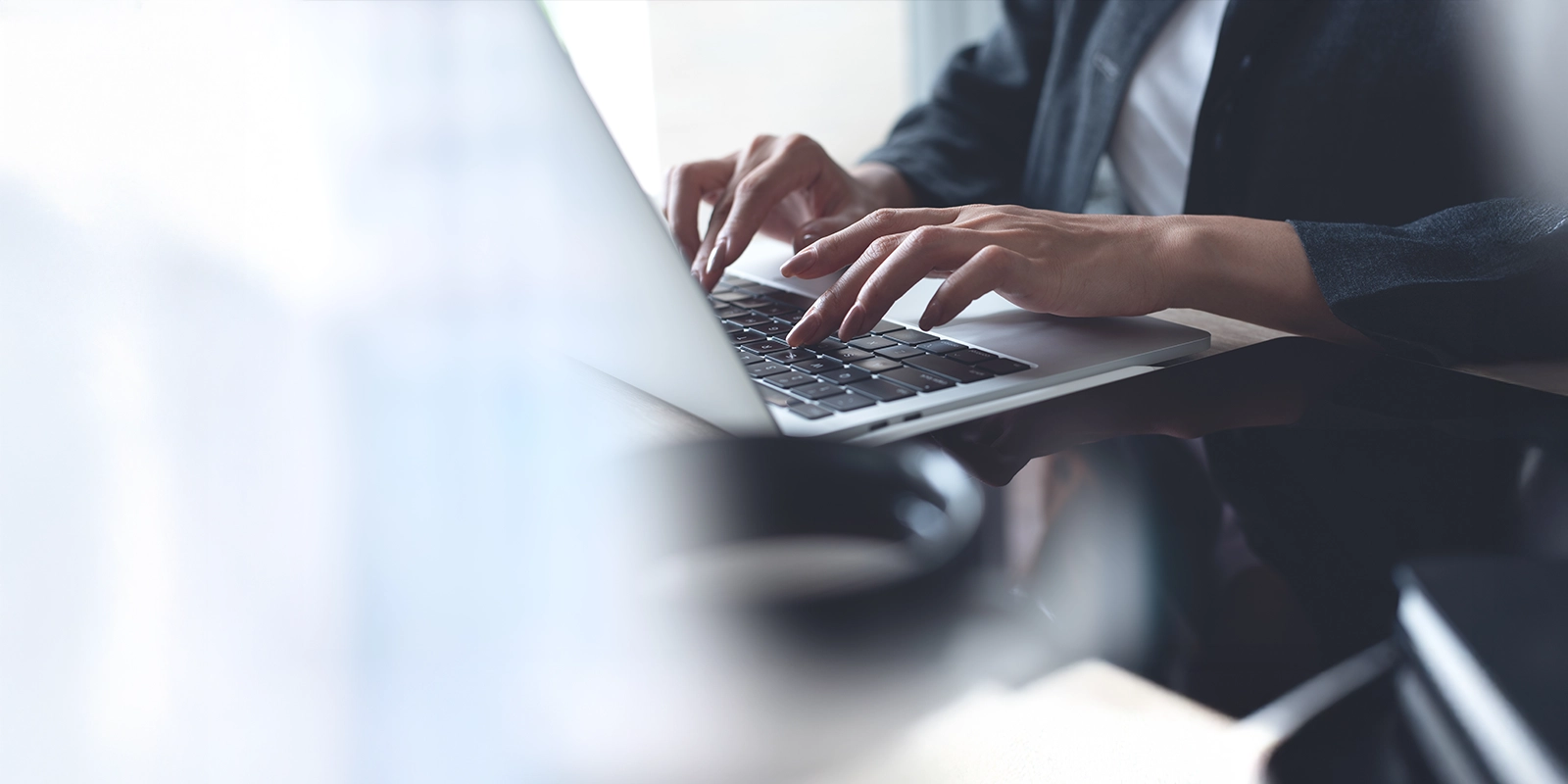 Business person typing on a laptop.