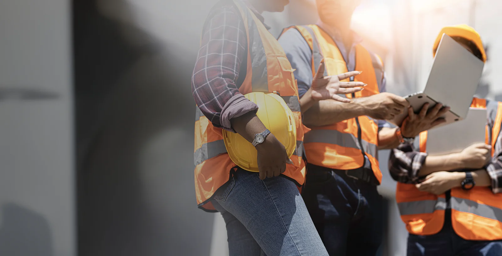 Construction workers carrying laptops and discussing something