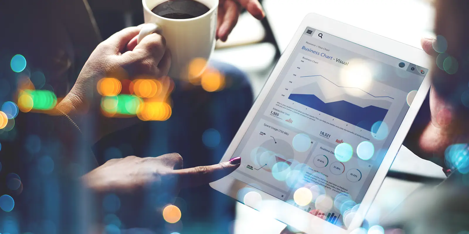 Business people pointing at charts on a tablet