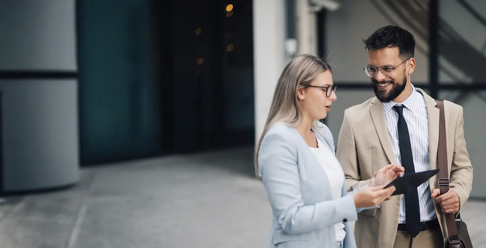 Two business partners discussing work on a tablet outside