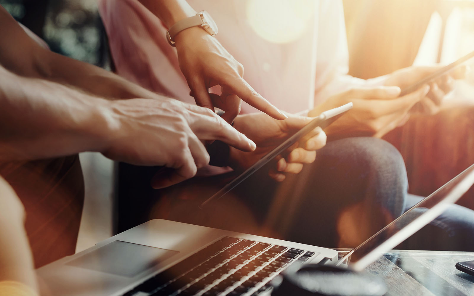 business team using cloud-accounting software on tables and laptops