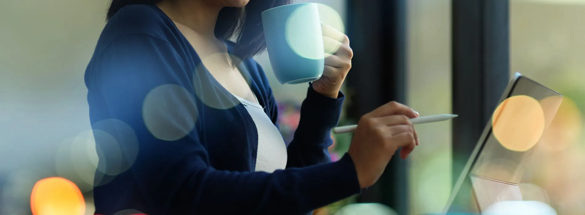 propriétaire d'entreprise buvant du café tout en travaillant sur une tablette