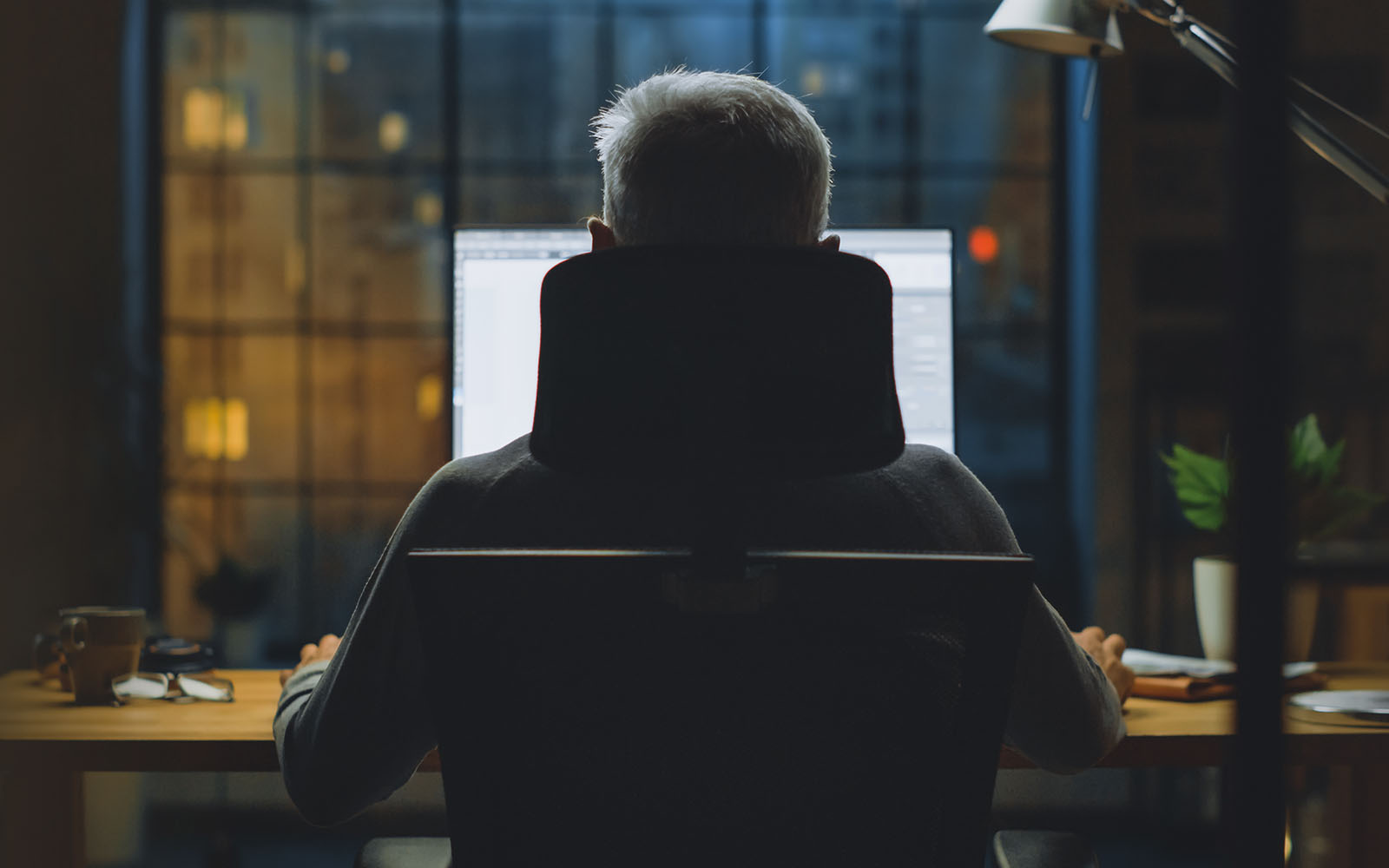 Businessman sitting at his home office working on a computer