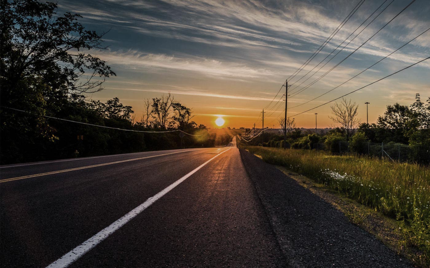 sunset on rural road with powerlines