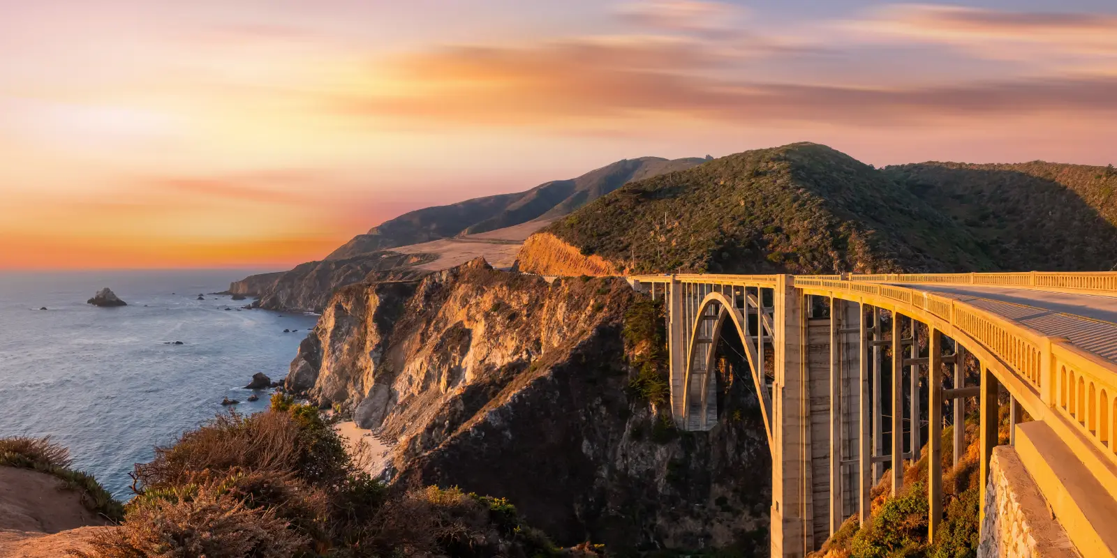 Bixby Creek Bridge at sunset along the Pacific coast.