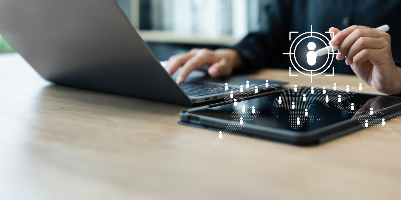 A white icon symbolizing a person with someone working on a laptop in the background.