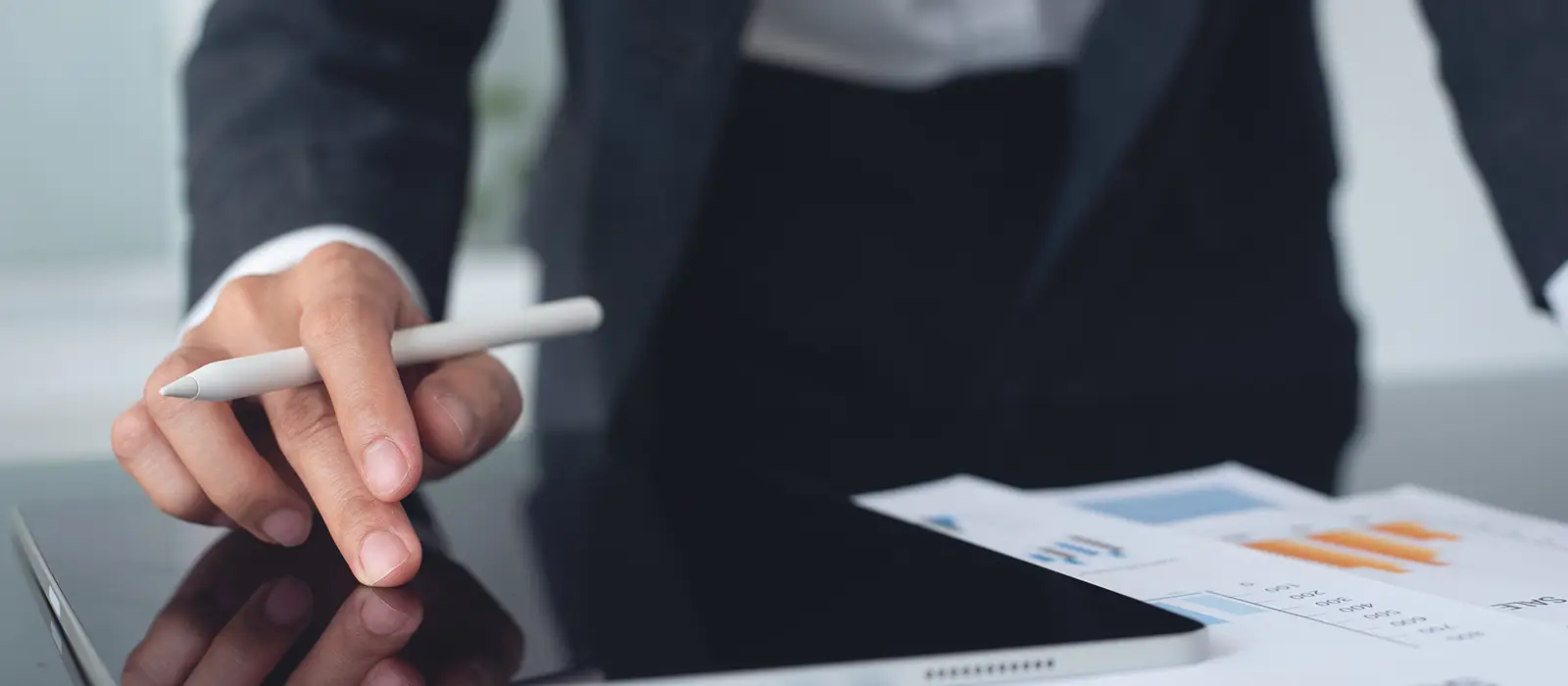 A professional using a digital tablet analyzing financial statements.