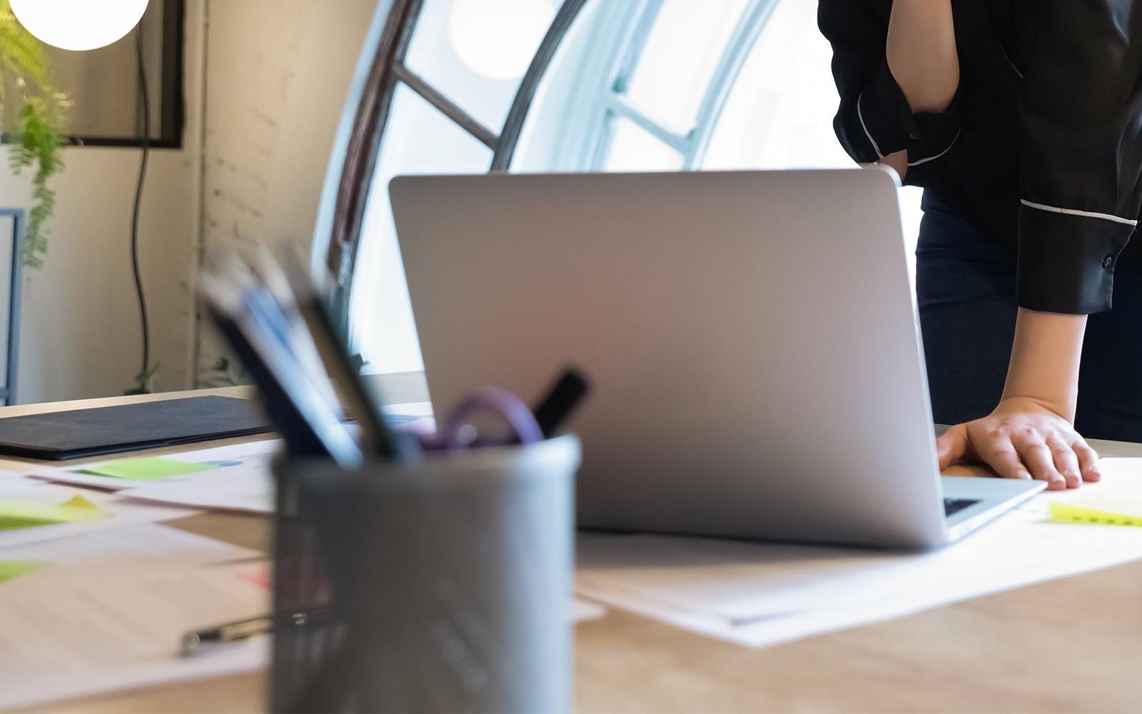 Femme d'affaires réfléchie, debout à table au bureau