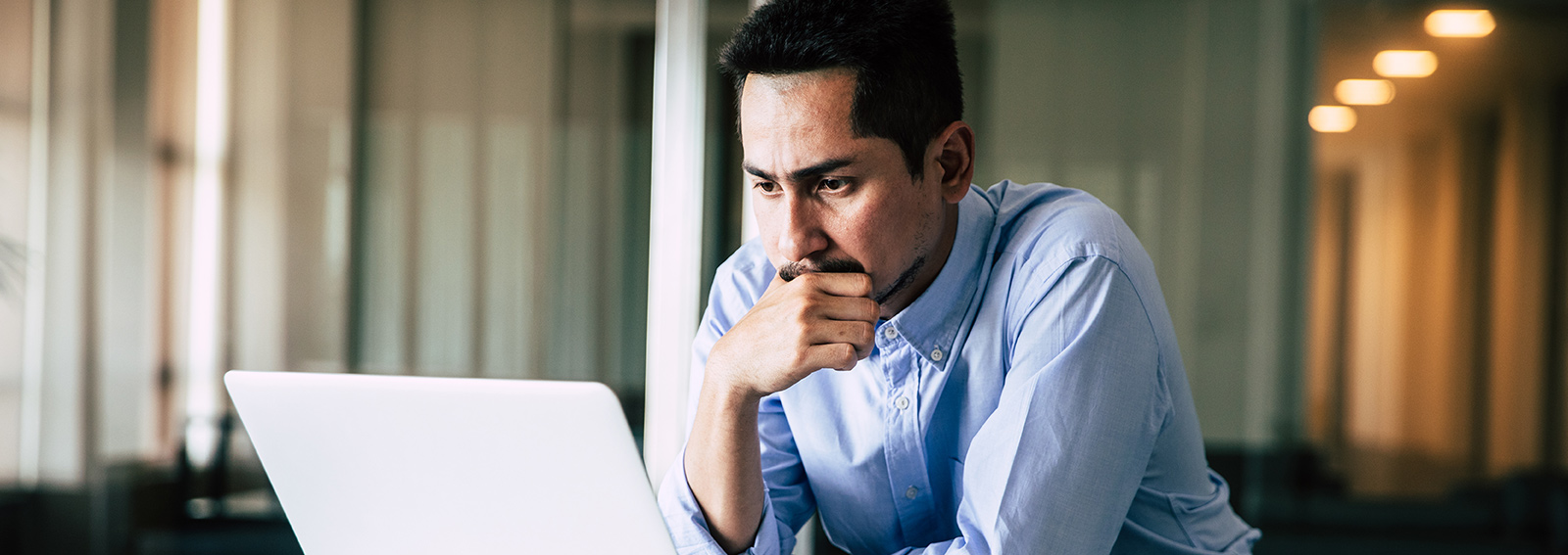 homme d'affaires utilisant un ordinateur portable debout travaillant dans un bureau moderne