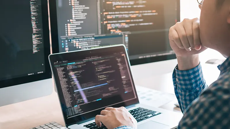 Business man looking at computer monitors