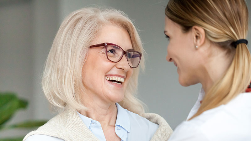 Two ladies smiling at one another