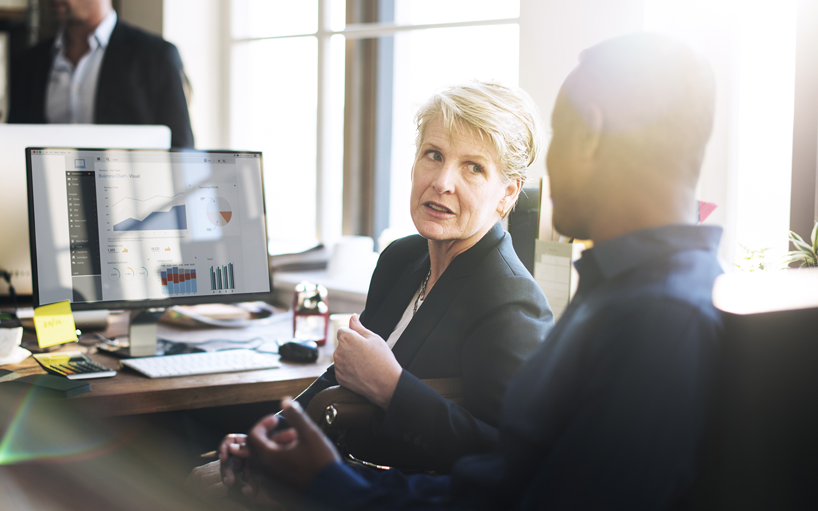 Two people collaborating at a computer desk