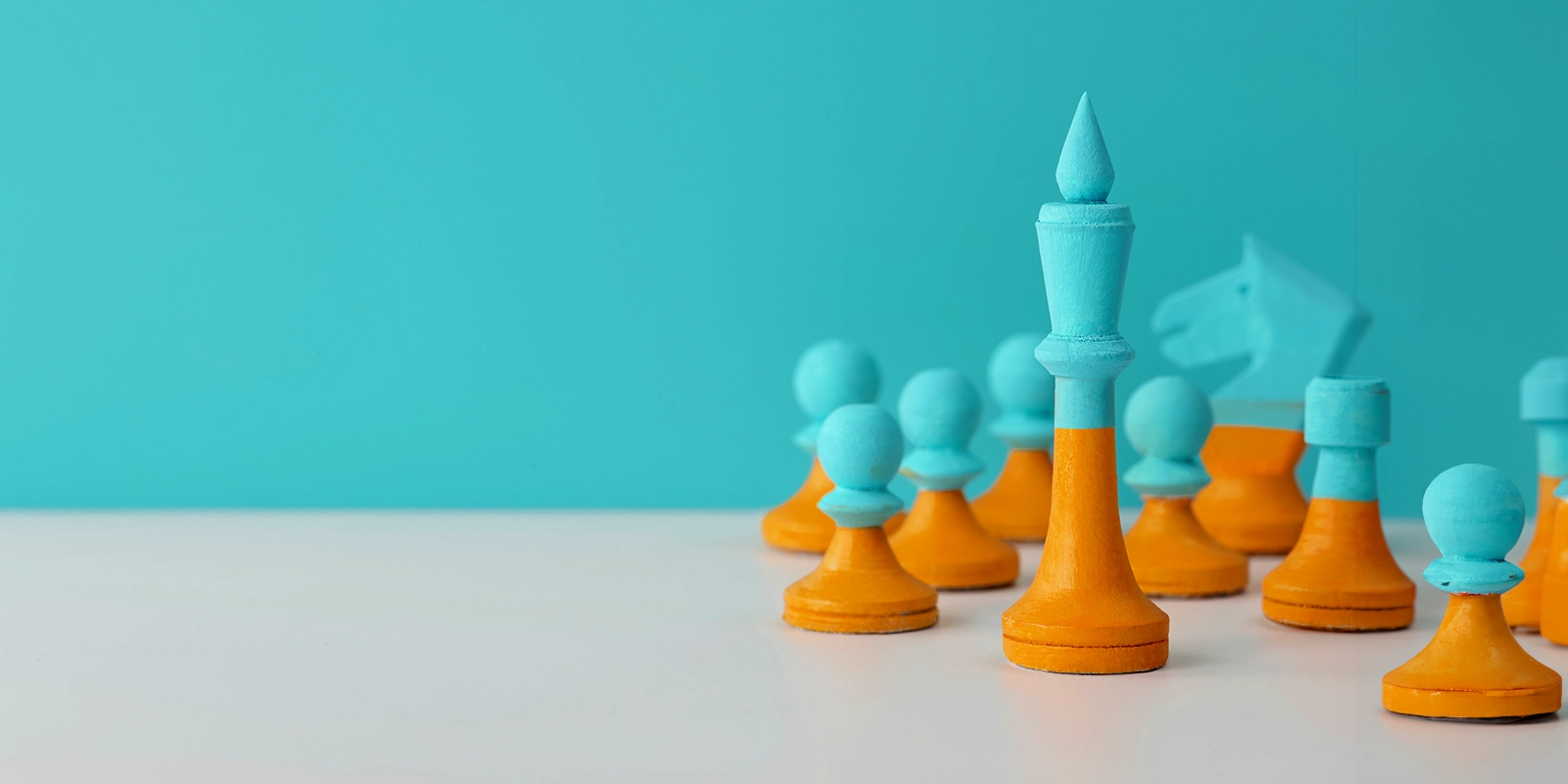 A group of orange and blue chess pieces arranged on a table, ready for a strategic game.