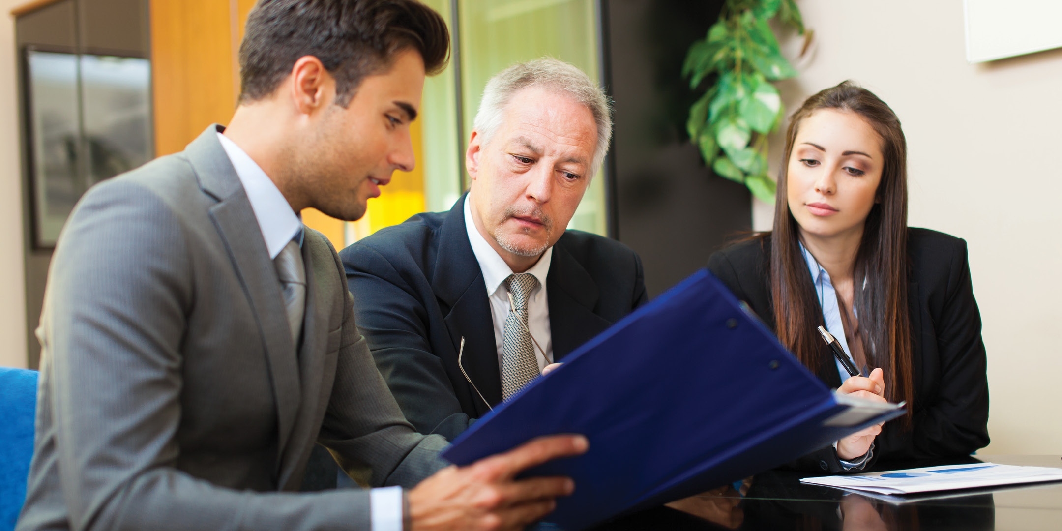 Three professionals looking at a document together at the office.