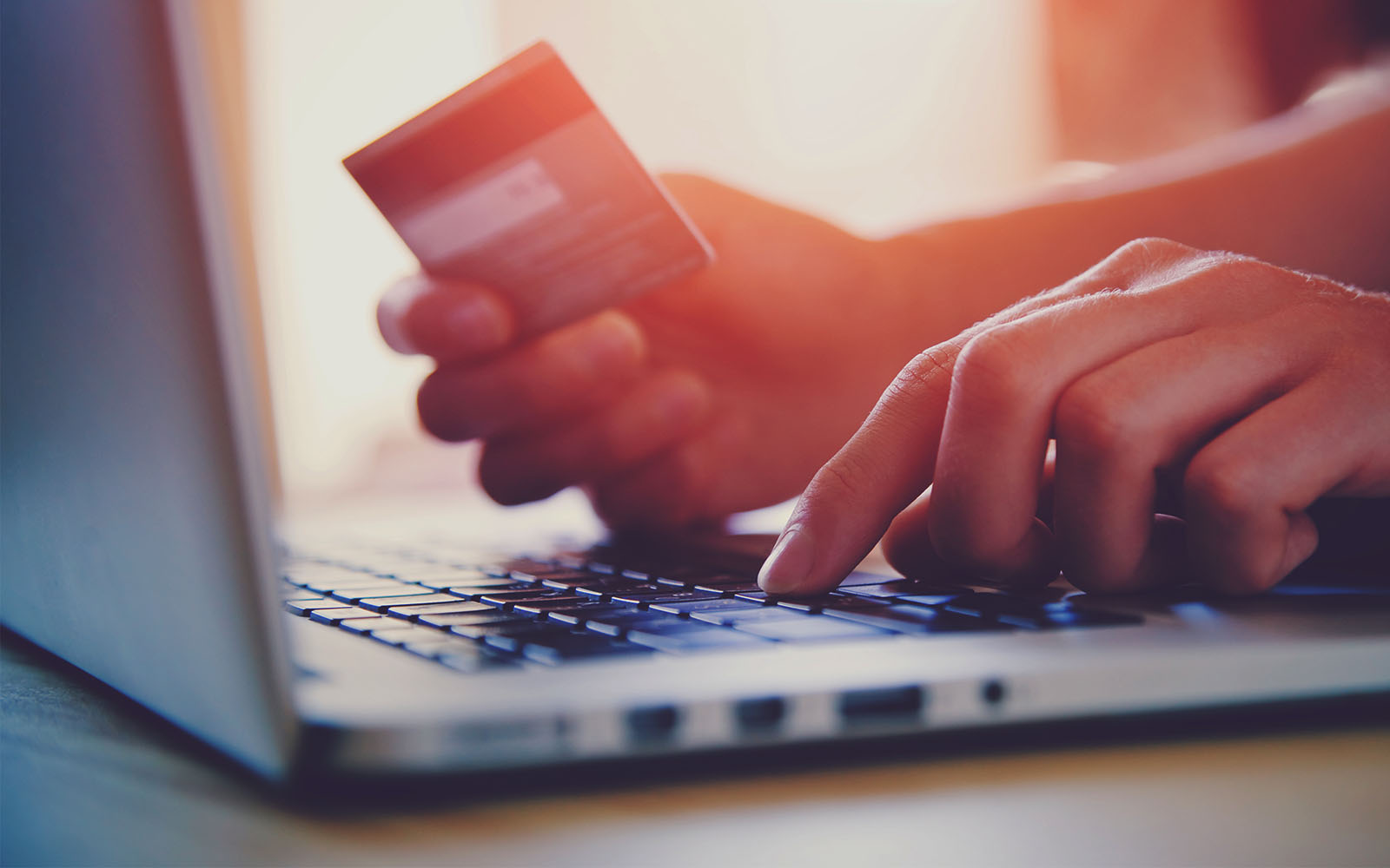 Person looking at credit card while on laptop