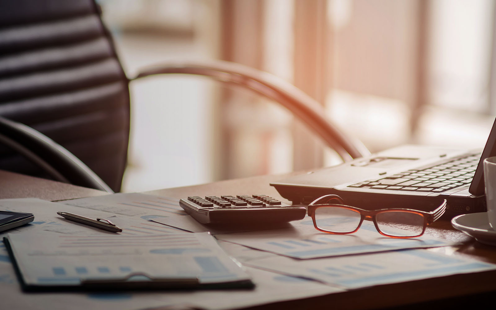 Bureau avec une tasse de café ordinateur portable pencalculator sur le bureau