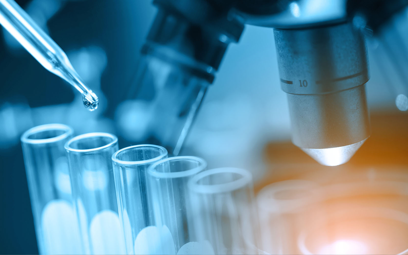 researcher using a microscope with lab glassware