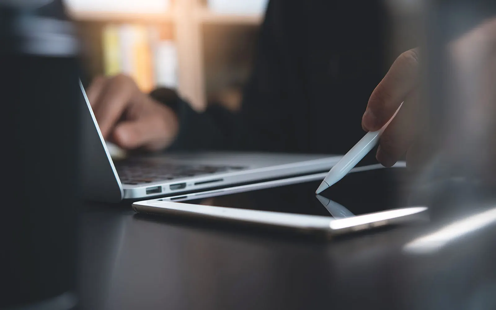 Gros plan sur une personne travaillant sur un ordinateur portable et une tablette