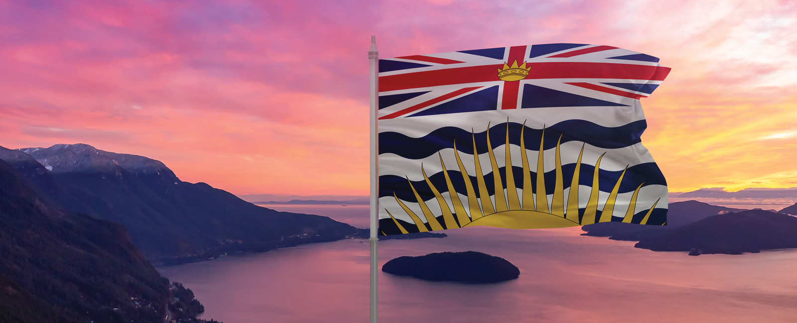 BC flag blowing in the wind with the sunset in the background