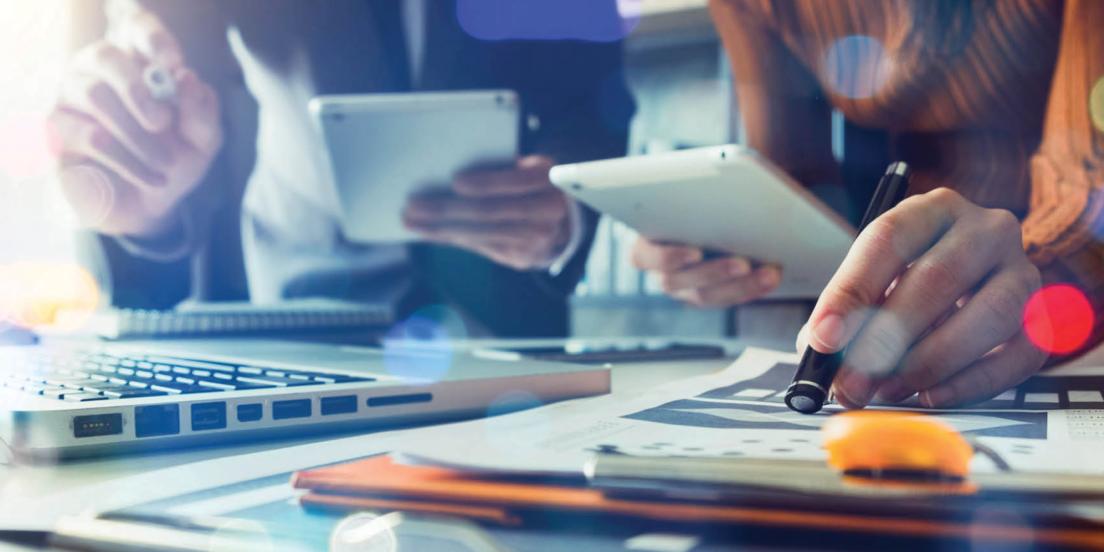 Man and woman holding ipads, reviewing documents