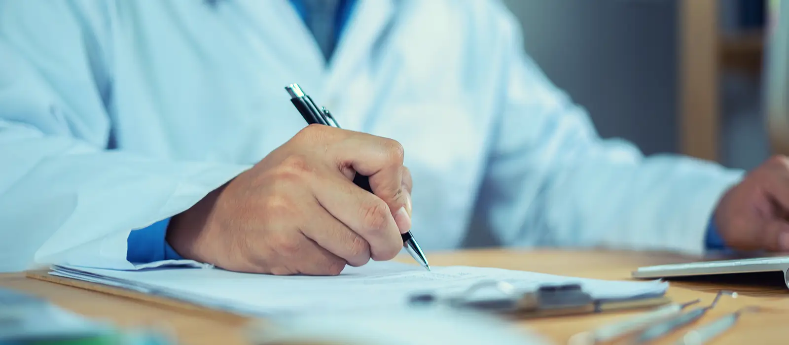  Dentiste avec presse-papiers et ordinateur portable sur le bureau