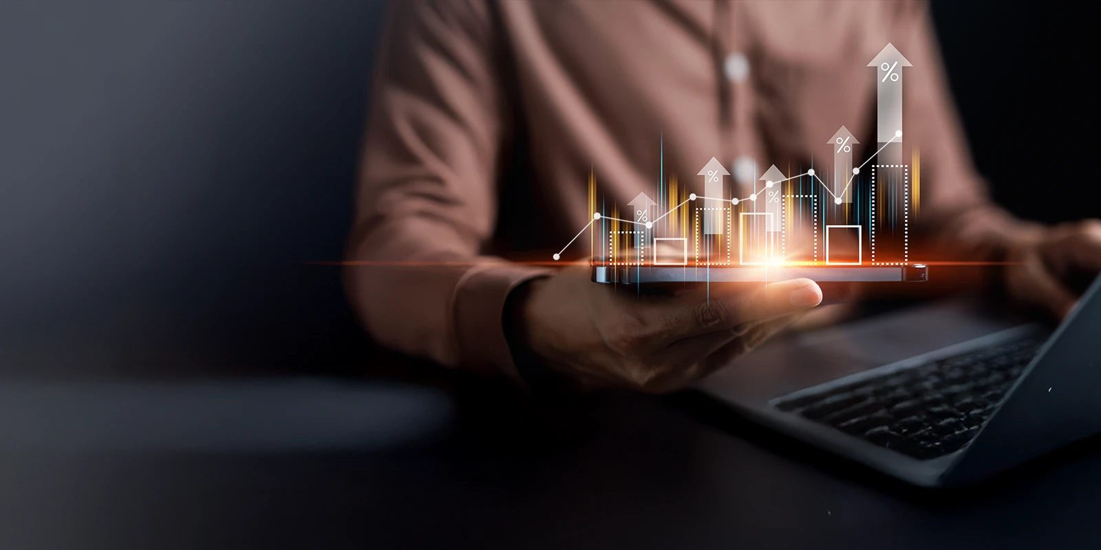 Blurred image of someone holding a smartphone with graphs coming out of it in the air.