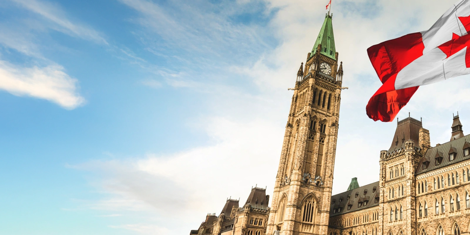 Canadian flag flying infront of the Canadian Parliament Building