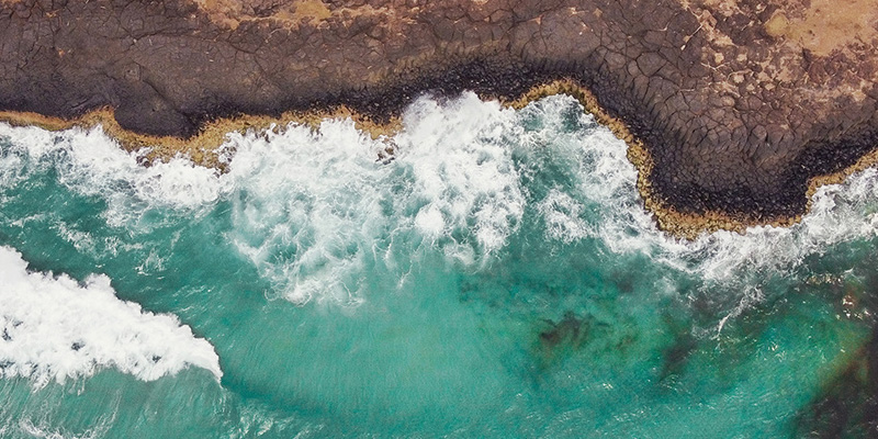 Aerial view of waves hitting a sea wall.